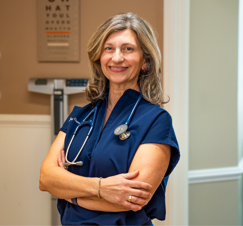 female doctor posing smiling with arms crossed in medical office